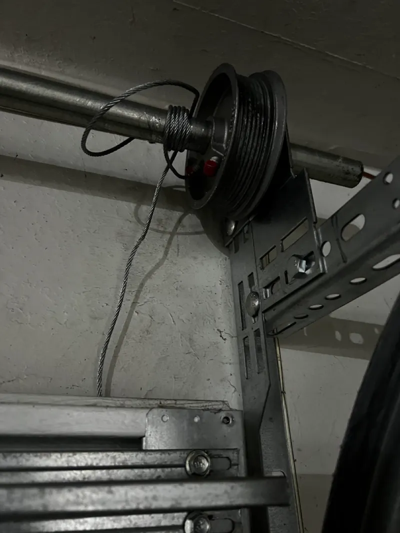 Garage door lift cable and drum being repaired